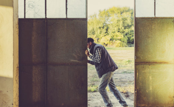 man opening doors of agricultural shed